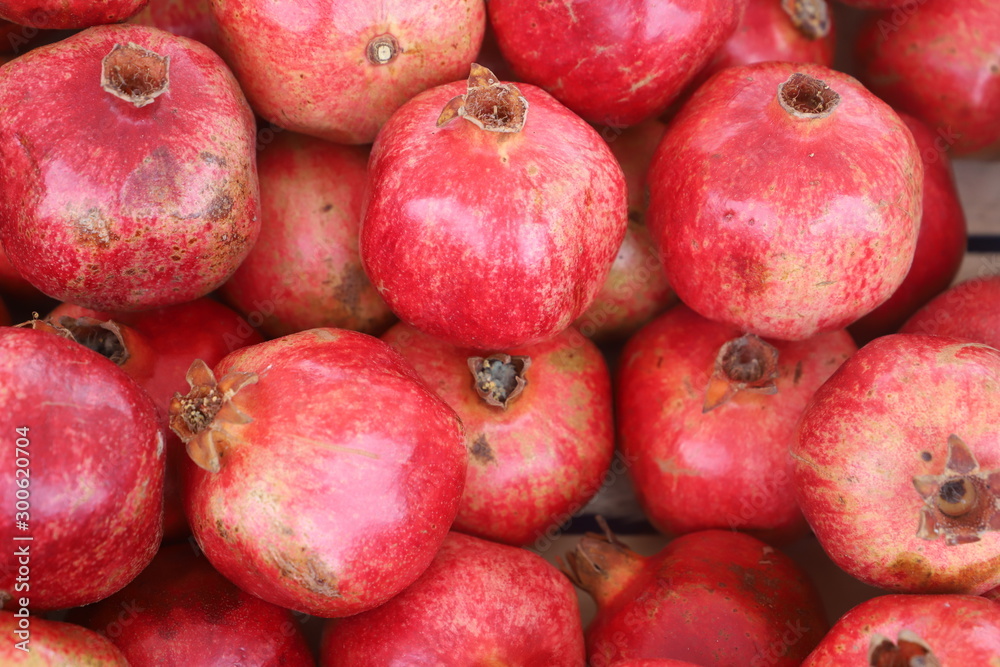 closeup of red pomegranates on display at the market closeup of red pomegranates on display at the market