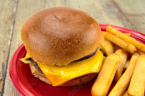 burger with beef and fries on a wooden table photo