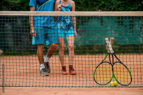 Low shot of athletes getting towards the net to take their rackets and balls. © yuriygolub