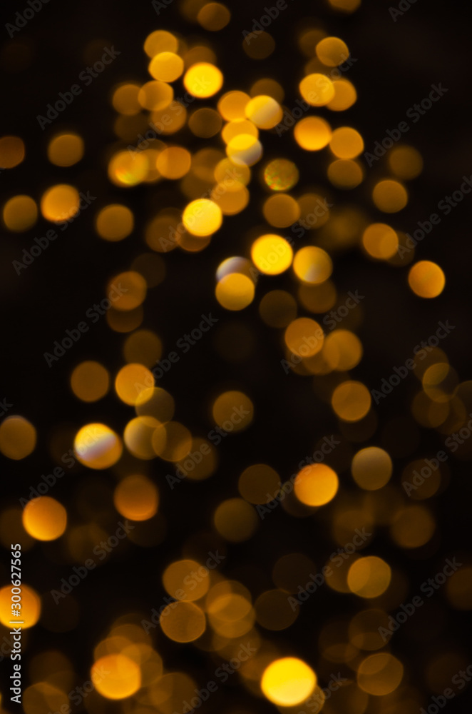 Abstract pattern of gold bokeh garland lights on a dark background