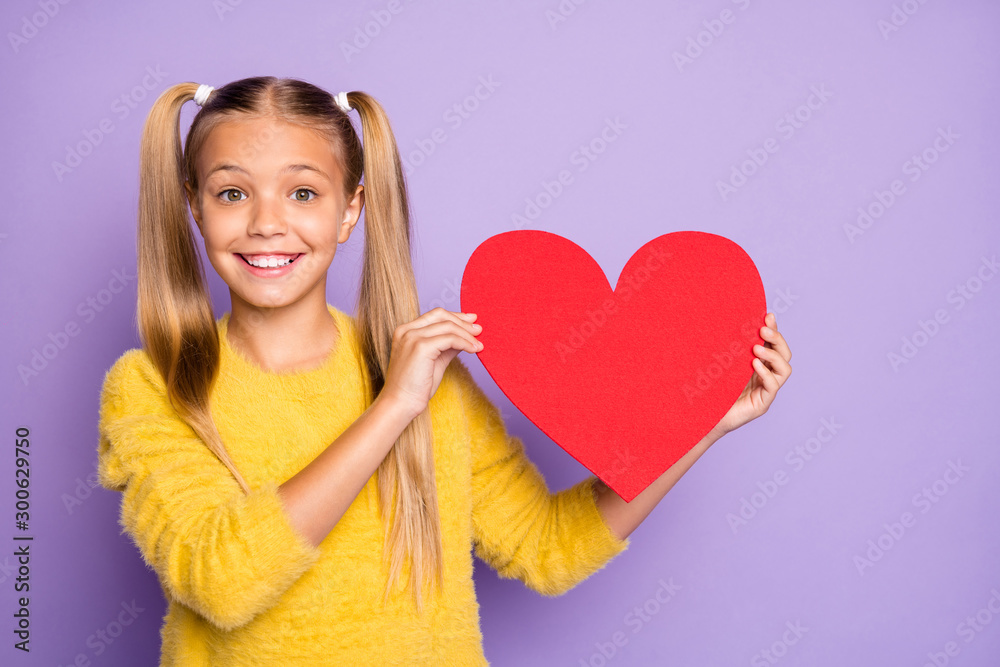 Portrait of funny funky kid enjoy valentine day holidays hold red big paper card heart she get wear yellow modern pullover isolated over purple color background Portrait of funny funky kid enjoy valentine day holidays hold red big paper card heart she get wear yellow modern pullover isolated over purple color background