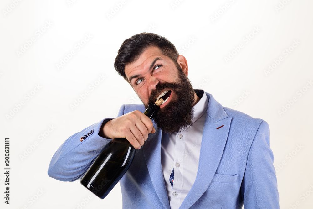 Fotka „Bearded man trying to open bottle of wine. Bad habits. Sexy male  model pulls out cork with teeth with bottle of wine. Brutal handsome man  opens his teeth bottle of champagne.