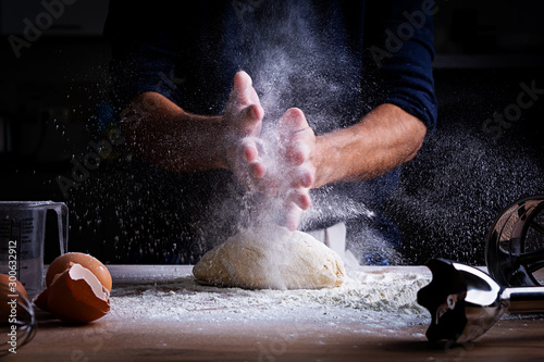 Male hands making dough for pizza, dumplings or bread. Baking concept.