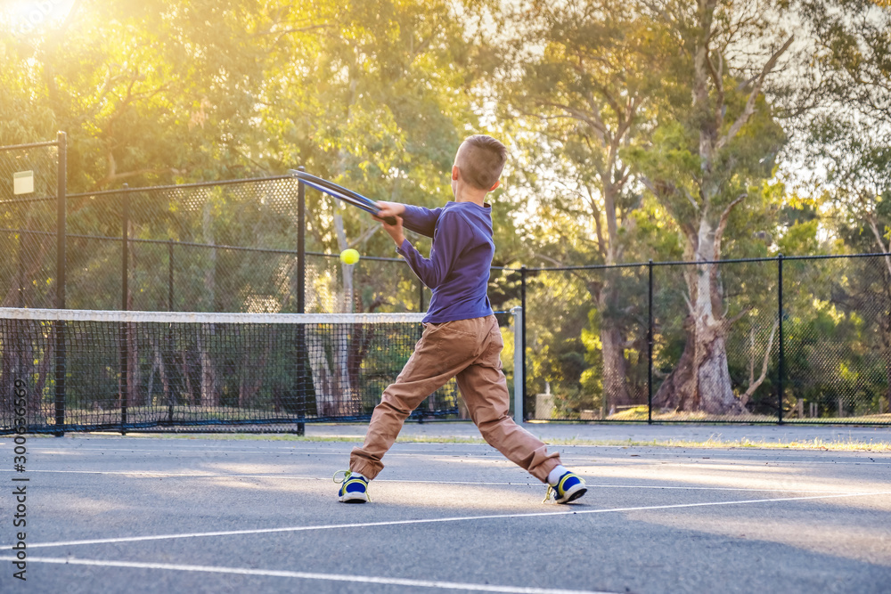 Australian boy playing tennis at outdoor court