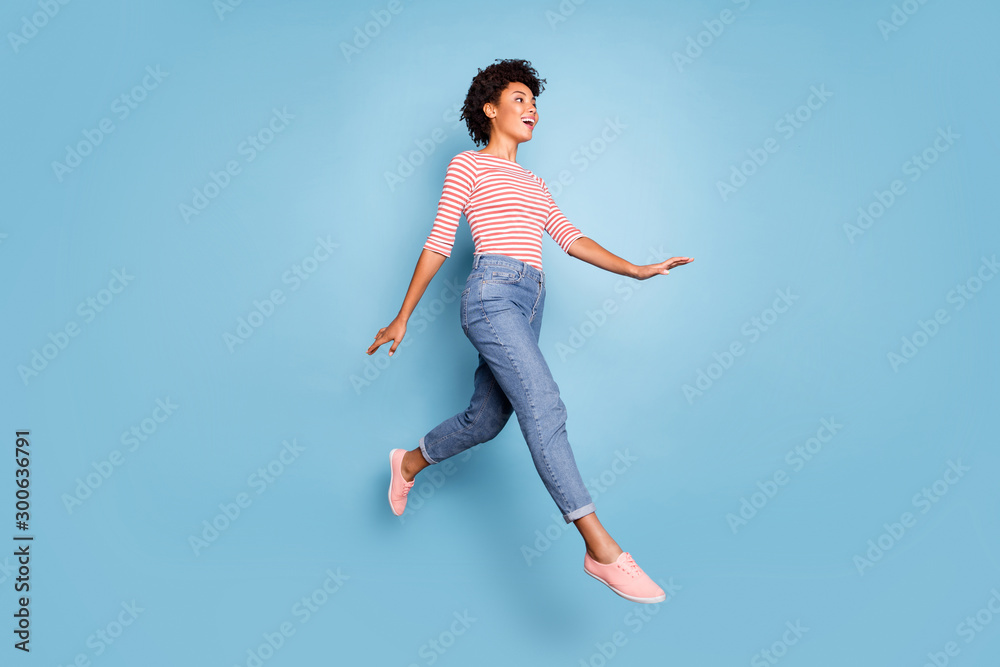 Full length profile side photo of excited cheerful afro american jump go walk having rest relax wear casual style clothes isolated over blue color background