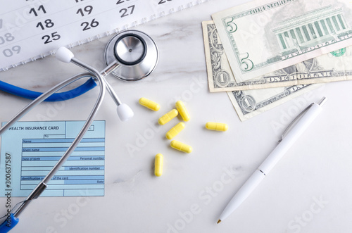 Calendar, pills, stethoscope, cash and health care card.Concept of high prices for monthly health insurance payments © uaPieceofCake