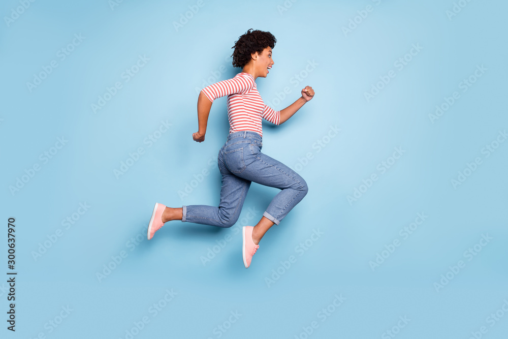 Full length body size side profile photo of cheerful positive nice pretty running jumping girl for sales in jeans denim striped shirt isolated blue pastel color background