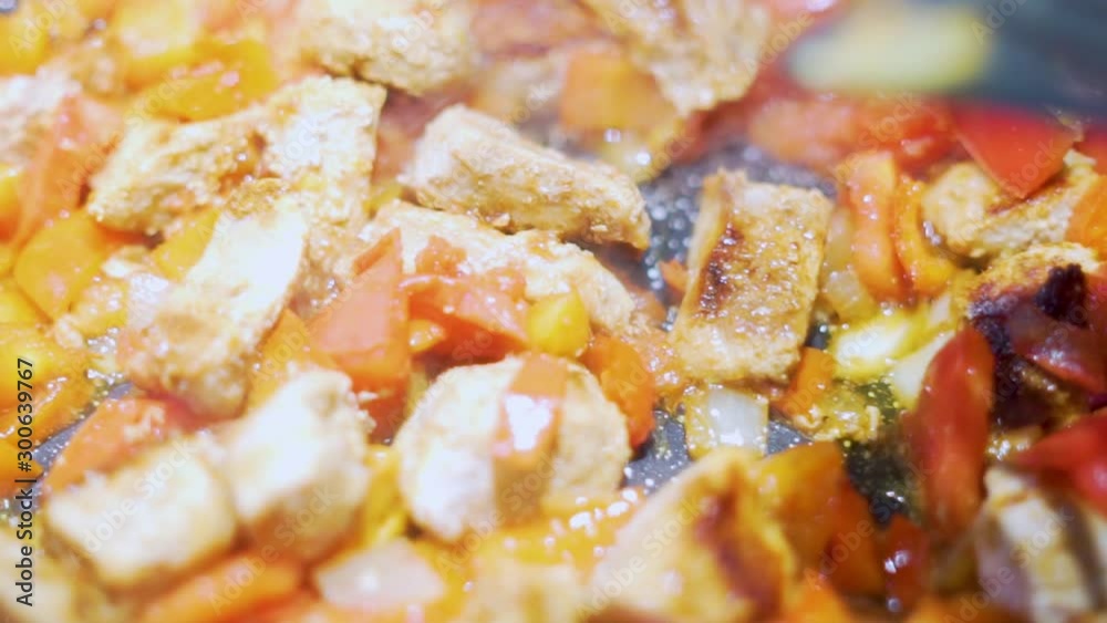 Close-up of stirring a delicious traditional meat dish with vegetables in a frying pan, macro, slow motion Close-up of stirring a delicious traditional meat dish with vegetables in a frying pan, macro, slow motion