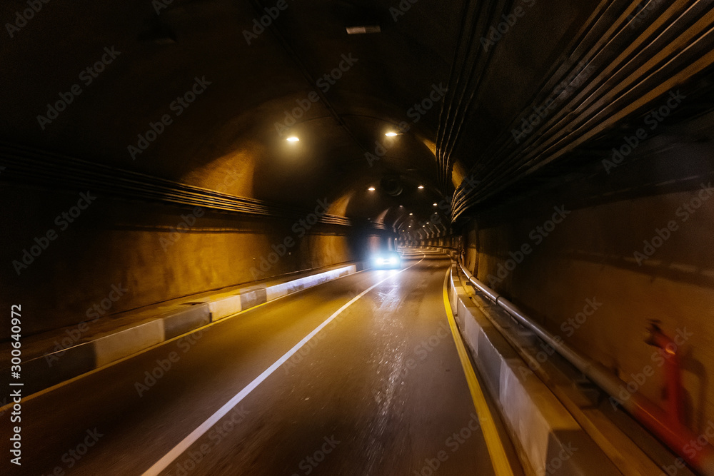 Road tunnel in mountain illuminated by lamps Road tunnel in mountain illuminated by lamps