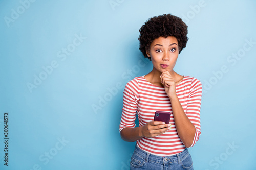 Foto Photo of interested wondered pensive pondering girl browsing through telephone u