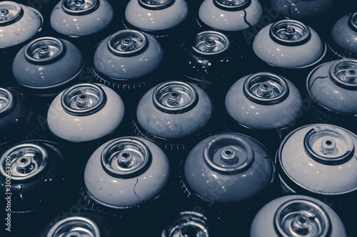 Spraycans with black and white theme lined up together on a table..Paint, art, pattern, texture, retro, graffiti, aerosol, urban, street, city concept. photo