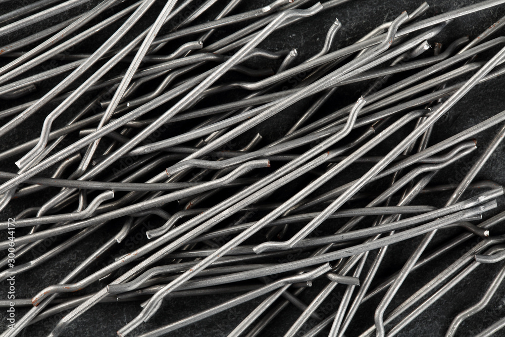 Extreme close up, top down view of end hooked steel macro fibers for concrete reinforcement. Construction industry background - obrazy, fototapety, plakaty 