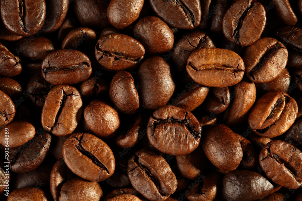 Fototapeta premium Extreme close up of freshly roasted, shiny coffee beans. Top down vew. Macro food texture background