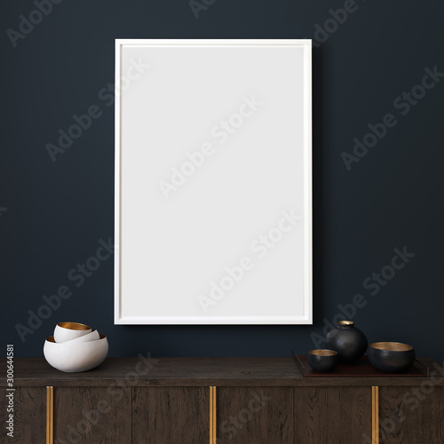 Picture mockup with white vertical frame on dark blue wall. Stylish dark interior with decor and wooden cupboard and blanket picture. Poster mockup. Minimalist modern interior design. 3D illustration.