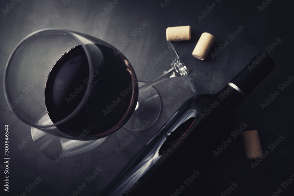 red wine bottle and glass on black marble stone background. top view