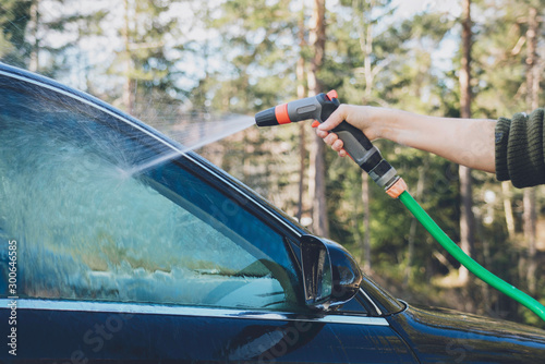 Washing car with water hose