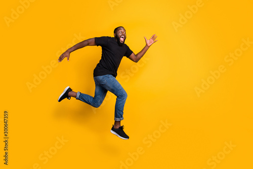 Full size profile side photo of funky crazy afro american guy jump go run after black friday discounts wear stylish trendy clothing isolated over yellow color background