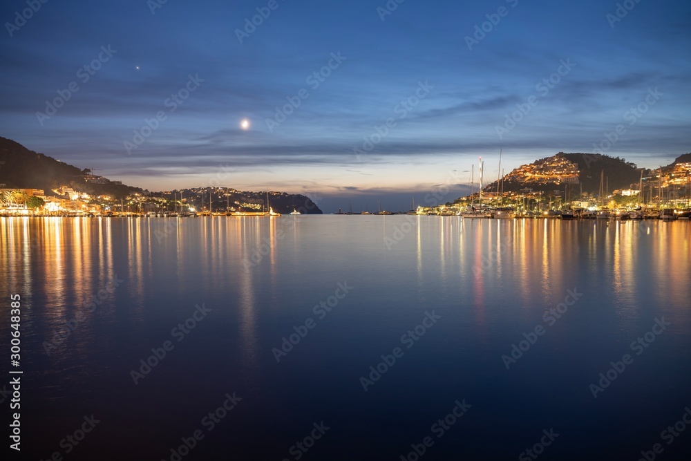 View of Port de Andratx (Balearic Islands, Spain) at dusk with clear water reflections of the night lights