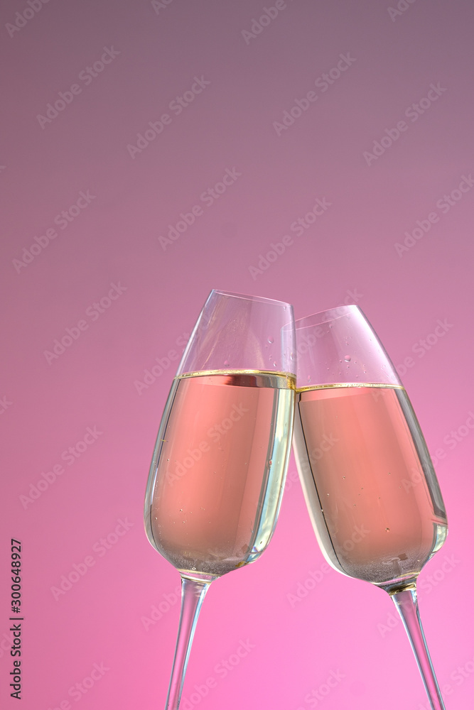 two glasses of sparkling wine on a pink background