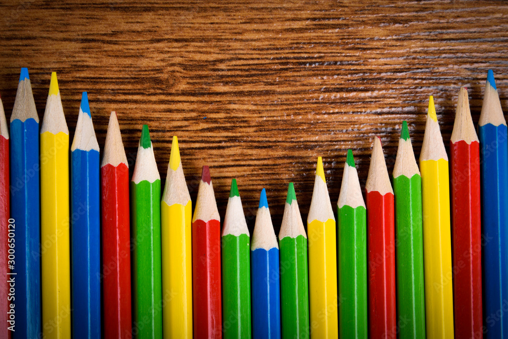 Different colored pencils on the brown wooden table background .Top view .Close up .Color .Pencil.Set Different colored pencils on the brown wooden table background .Top view .Close up .Color .Pencil.Set