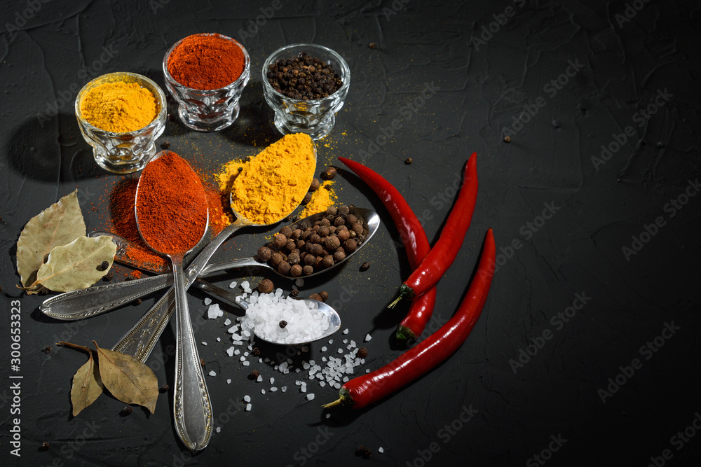 Various spices spoons on stone table.On dark concrete background.Herbs and spices on wooden table. Top view with space for your text Various spices spoons on stone table.On dark concrete background.Herbs and spices on wooden table. Top view with space for your text
