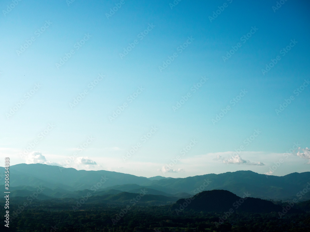 Wide-angle view of complex mountain range in northern Thailand with clear blue sky for use as background or wallpaper.