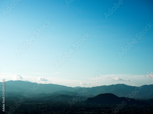 Wide-angle view of complex mountain range in northern Thailand with clear blue sky for use as background or wallpaper.