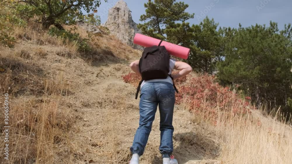 Girl traveler rises to top of mountain. woman exerts effort when climbing on foot to mountain. Girl traveler rises to top of mountain. woman exerts effort when climbing on foot to mountain.