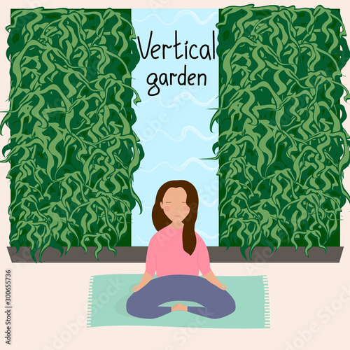 Girl resting and doing yoga in a room with vertical garden. Wall with vertical landscaping. Houseplants. Modern eco design for home and office.