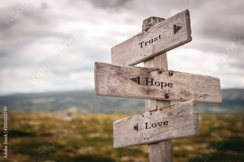 Trust hope and love text on wooden sign outdoors photo