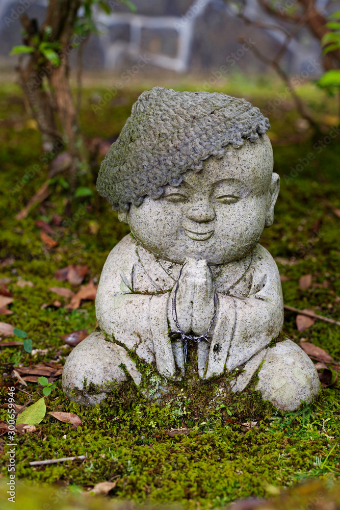 Jizo stone statue wearing knitted and cloth hats.