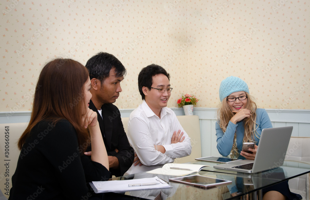group of asian business people looking at the phone and talking during meeting group of asian business people looking at the phone and talking during meeting