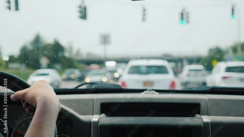 The driver is in traffic, in the frame his hands on the steering wheel and traffic congestion The driver is in traffic, in the frame his hands on the steering wheel and traffic congestion