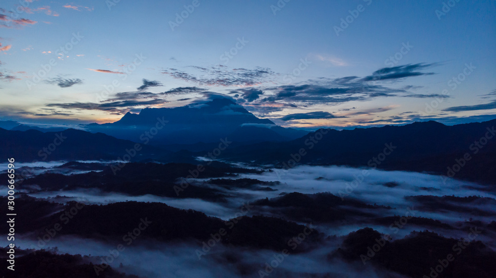 Rural landscape with dramatic sea of cloud during sunrise with Mount Kinabalu at Saba, Borneo