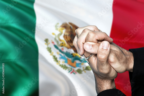 Mexico flag and praying patriot man with crossed hands. Holding cross, hoping and wishing. photo