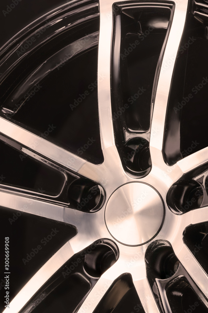 car alloy wheel black and white spokes on black background, element close up vertically car alloy wheel black and white spokes on black background, element close up vertically