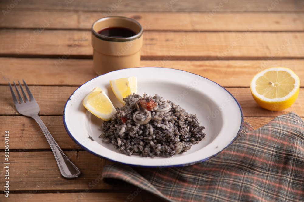 Plate of black rice with squid and prawns or Valencian black paella Plate of black rice with squid and prawns or Valencian black paella