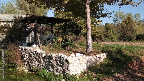 Panning from  a Small rolling creek to a stone house on a sunny day in nature in Northern Greece, Kefalari, Drama photo