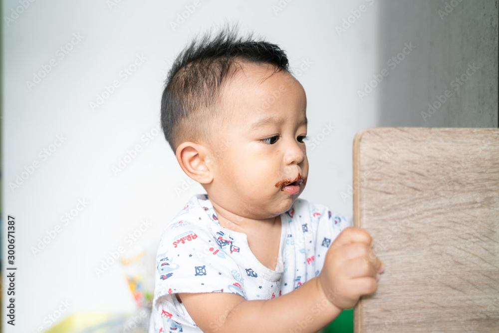 Asian babu boy with chocolate cream dirty on lips of mouth Asian babu boy with chocolate cream dirty on lips of mouth
