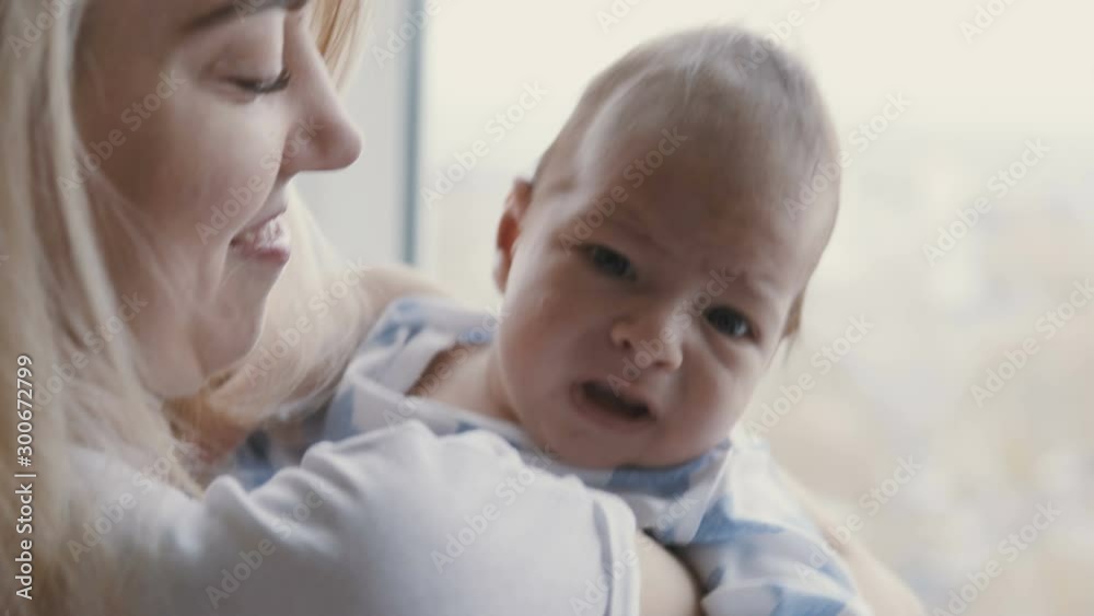 Happy young family - young mother holding her new born son, kissing and hugging. Happy family concept. Happy young family - young mother holding her new born son, kissing and hugging. Happy family concept.