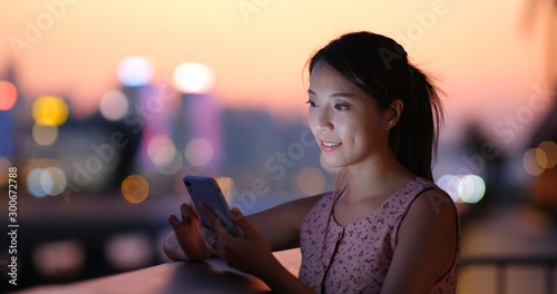 Photography Woman check the location on cellphone in city of Hong Kong at sunset time
