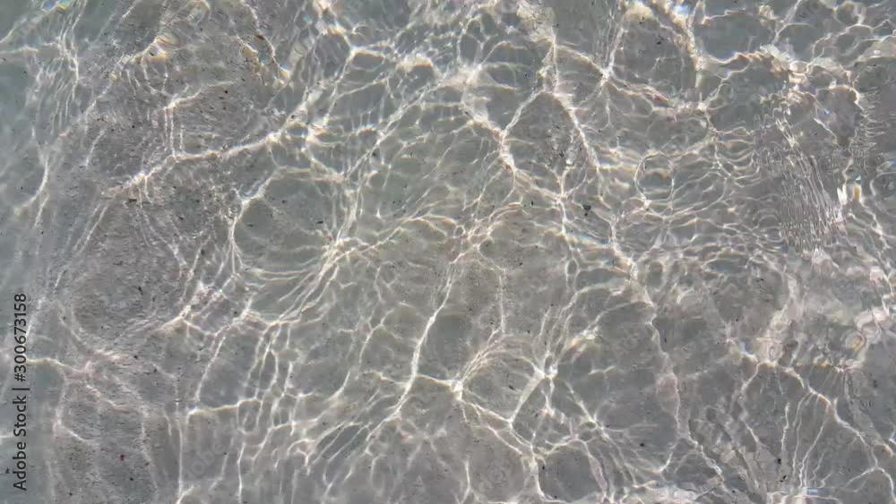 Sun rays reflected on bottom of the sea with white sand of Maldives, clear transparent sea water, concept design