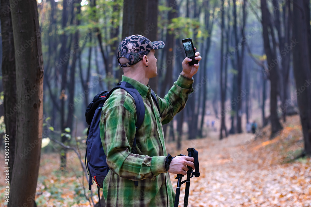 Man with backpack hiking on the mountain track taking photo of the wildlife. - Image