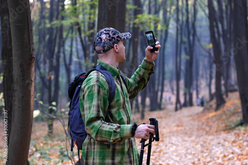 Man with backpack hiking on the mountain track taking photo of the wildlife. - Image