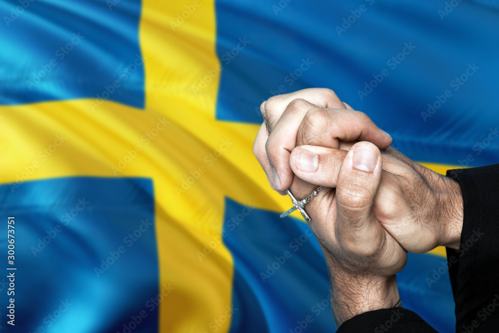Sweden flag and praying patriot man with crossed hands. Holding cross,  hoping and wishing. Stock Photo | Adobe Stock