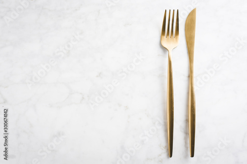 Gold cutlery set on marble background
