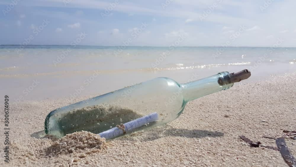 Vintage message in bottle coming from the sea on white sandy beach in Thailand, copy text