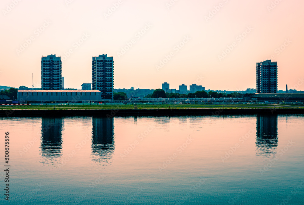 The North Woolwich skyline, with the tower blocks reflected on Thames canal. North Woolwhich is an industrialised settlement hemmed in by the King George V Dock and the River Thames, in East London,UK