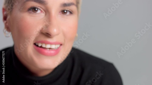 closeup portrait caucasian blond woman amiling wide and watching to the camera and aside photo