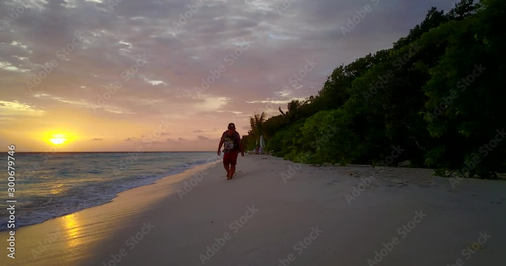 tourist walking on the tropical sandy beach with palm trees adjusting backpack while enjoying breathtaking sunset Thailand tourist walking on the tropical sandy beach with palm trees adjusting backpack while enjoying breathtaking sunset Thailand